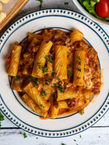 Overhead look at Instant Pot baked ziti on a plate with a salad in the background.